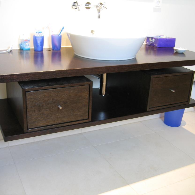 Ein modernes Badezimmer mit einem großen Waschbecken auf einem dunkelbraunen Badmöbel nach Maß, unterstützt durch einen blauen Sockel.