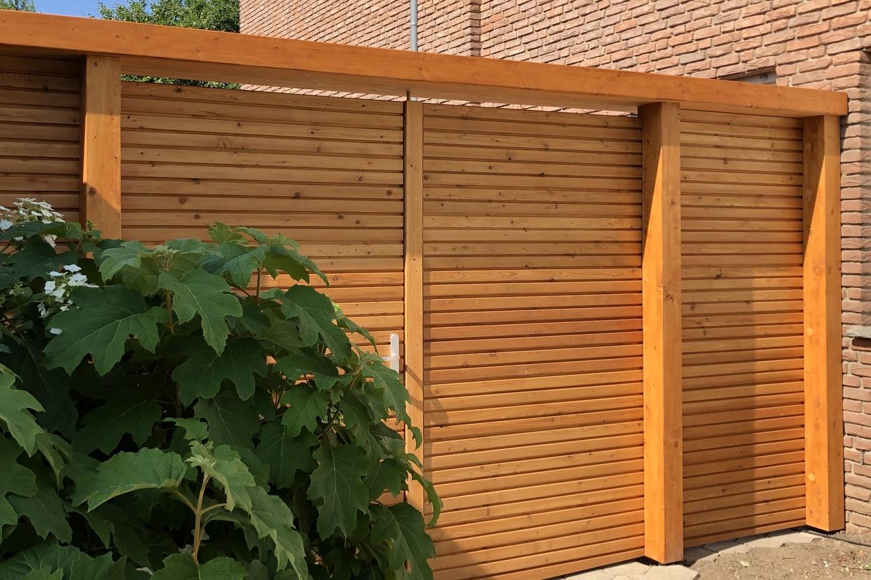 Holztor für den Außenbereich vor Pflanze neben Hauswand