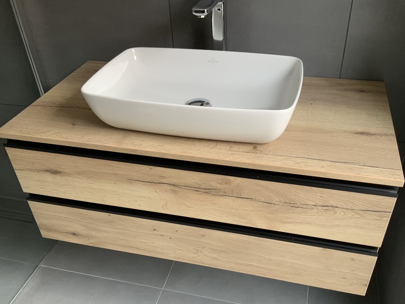 Unterschrank aus Holz unter weißem Waschbecken