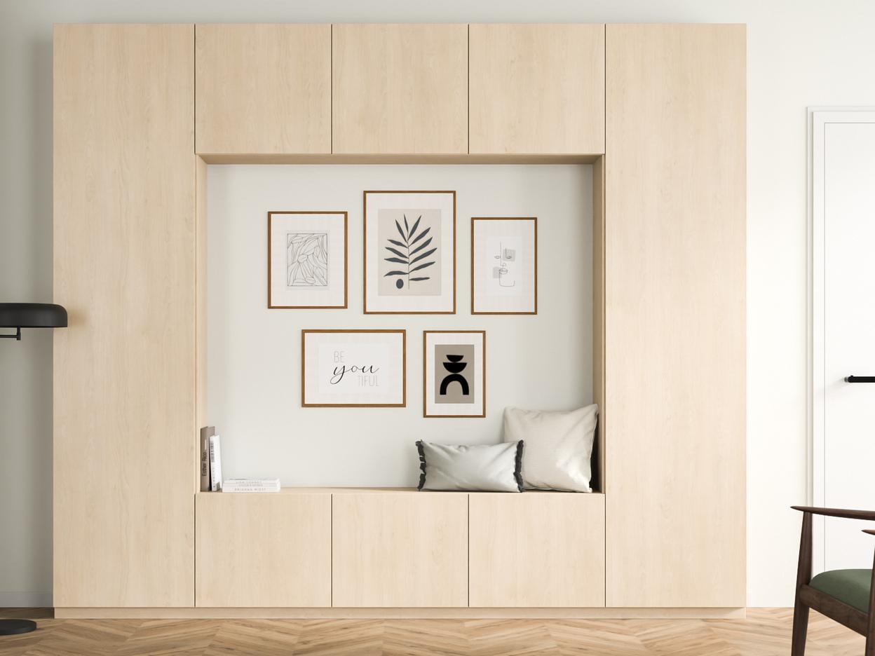 Ein maßgefertigter, heller Holzschrank mit eingebauter Sitznische und dekorativen Rahmen an der Wand, harmonisch in einen gemütlichen Wohnbereich integriert.